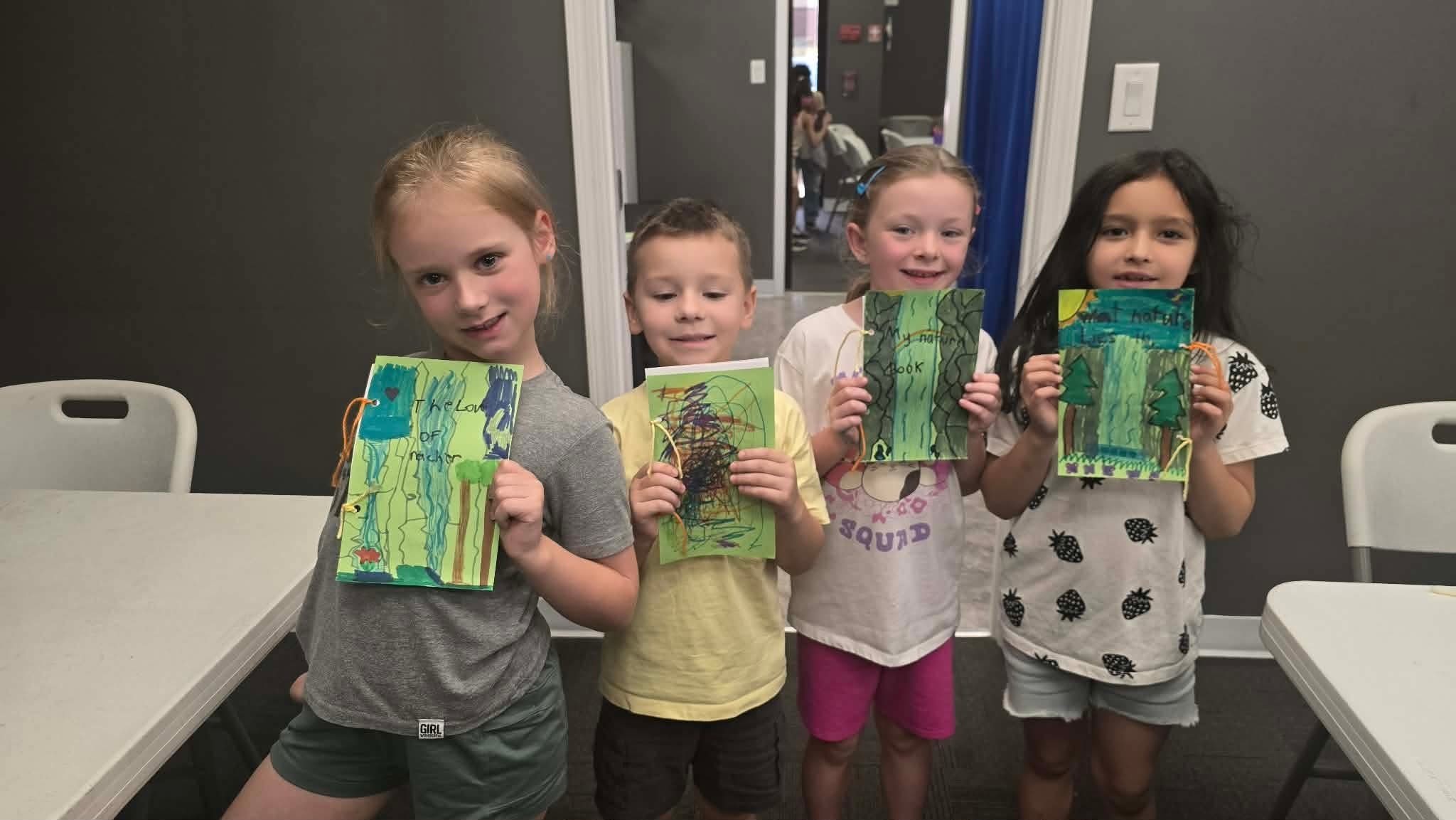 Campers showing their handmade nature books